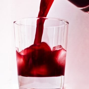 cherry juice being poured into a glass