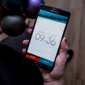 timer and juggling balls in hand