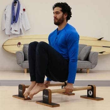 The Benefits of Parallettes Training and How to Overcome Challenges 5 Chris doing a tuck hold on parallettes