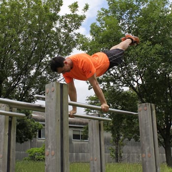 The Benefits of Parallettes Training and How to Overcome Challenges 1 Ryan swinging around on pbars