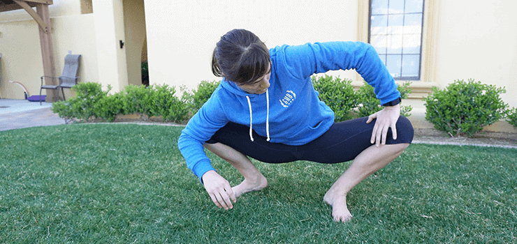woman stretching hip in squat