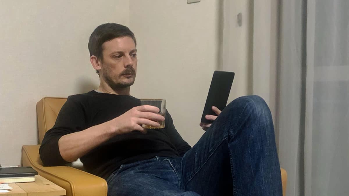 Andy Fossett pretending to read and enjoy some bourbon