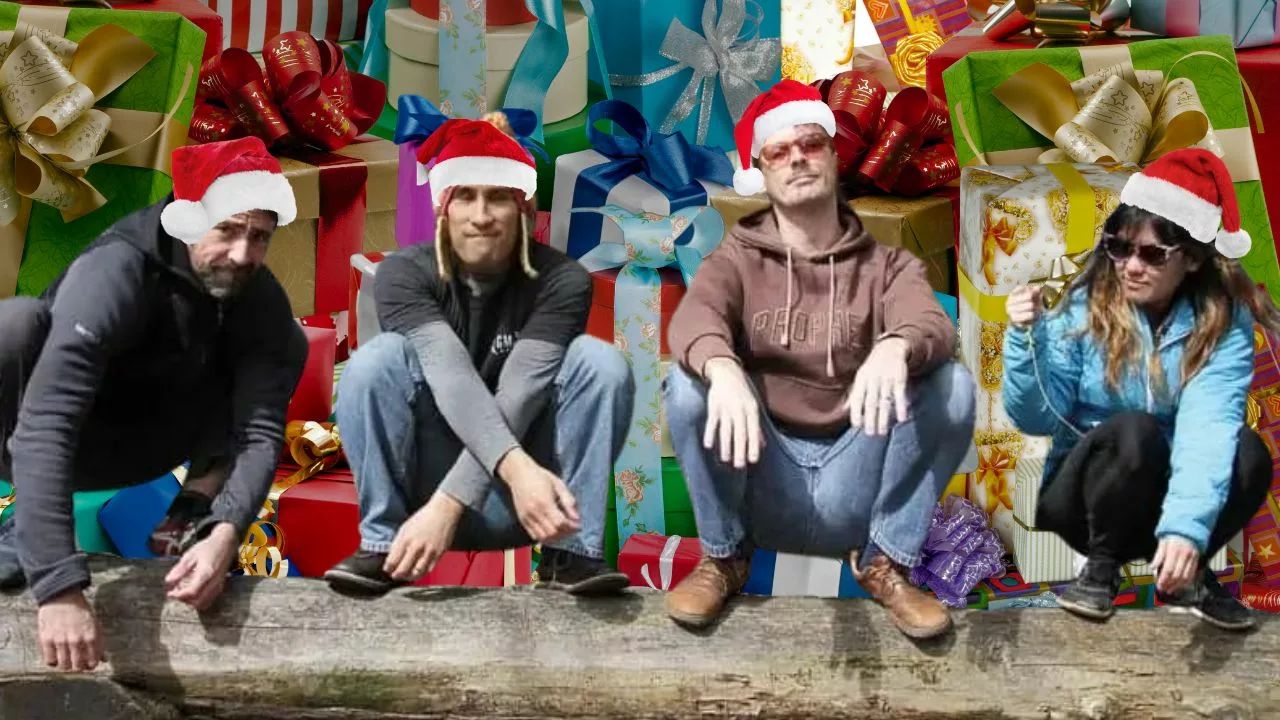 Ryan, Jarlo, Andy, and Amber are squatting on a log in front of a mountain of Christmas presents.