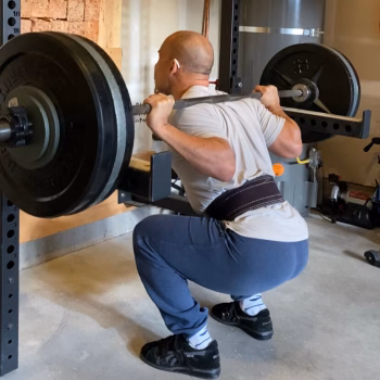 man squatting a 300 pound barbell